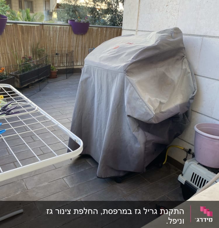 גריל מכוסה בכיסוי אפור במרפסת